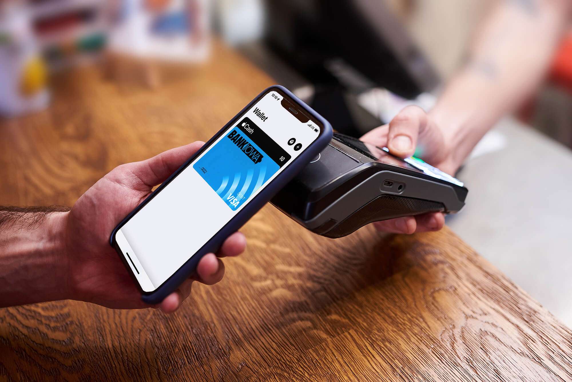 Man holding smartphone near checkout scanner to use his mobile digital wallet