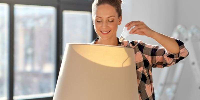 Woman installing a light bulb.