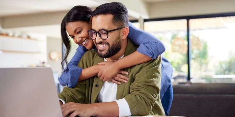 Couple planning their wedding finances on their laptop.