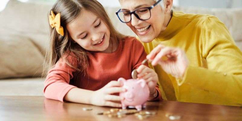 Mom teaching her daughter how to save money.