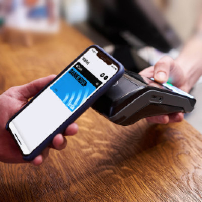 Man holding smartphone near checkout scanner to use his mobile digital wallet