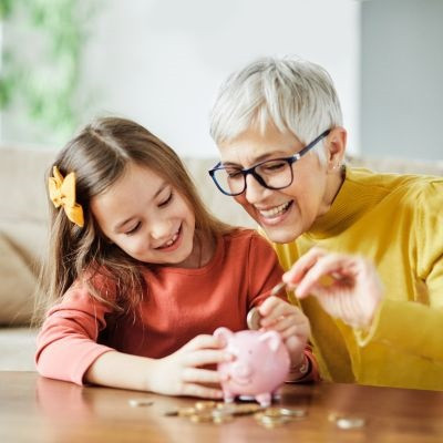 Grandma teaching granddaughter how to save money.